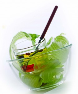 Lettuce with olive oil in bowl, close-up